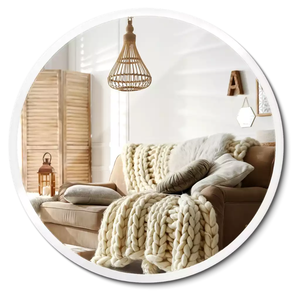 Round mirror hanging in a white frame