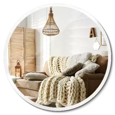 Round mirror hanging in a white frame