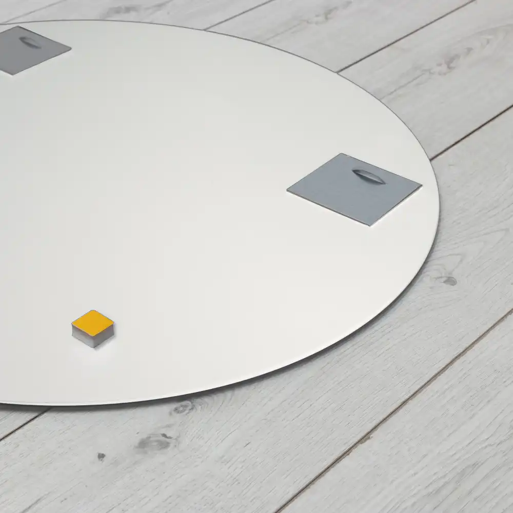 Round mirror hanging in a white frame