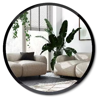 Round mirror hanging in a black frame