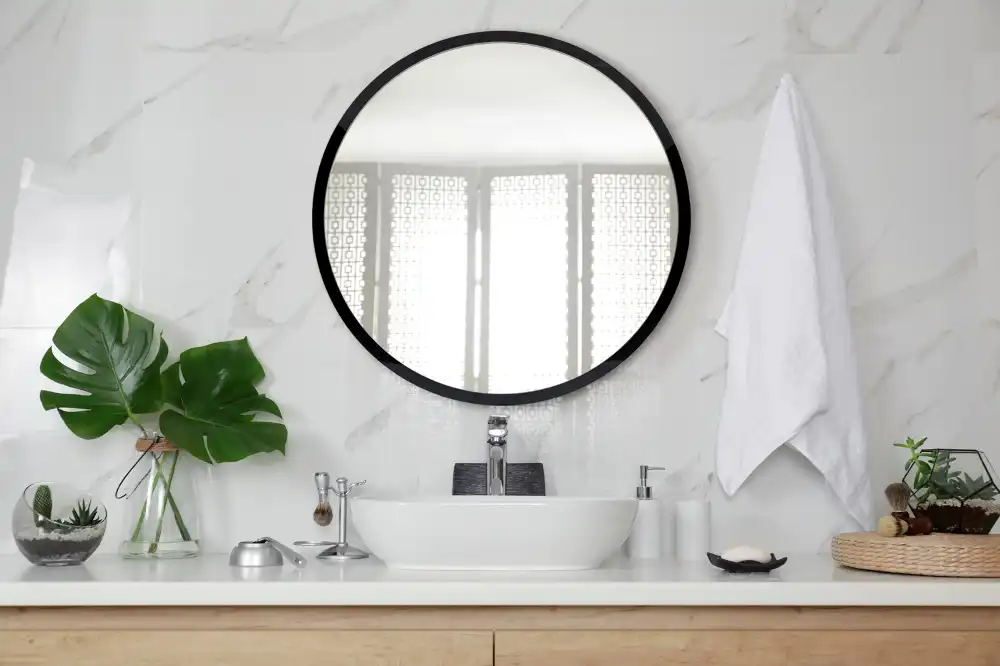 Round mirror hanging in a black frame